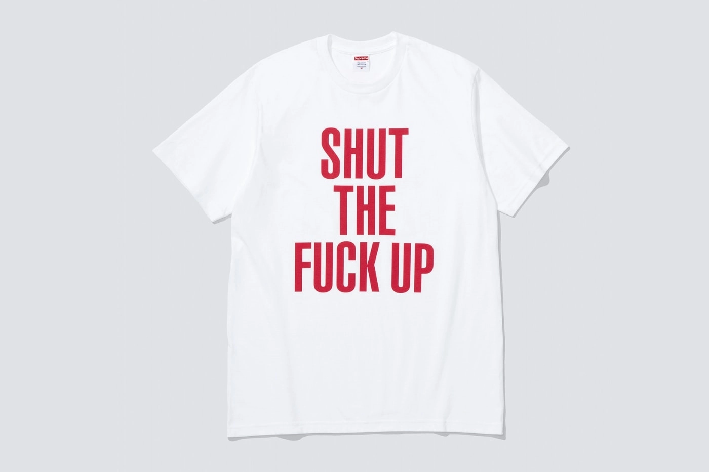 t-shirt blanc Supreme avec inscription rouge 'Shut the Fuck Up' sur fond gris