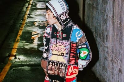 Hoodie Supreme x Number Nine coloré porté dans une ruelle urbaine sombre