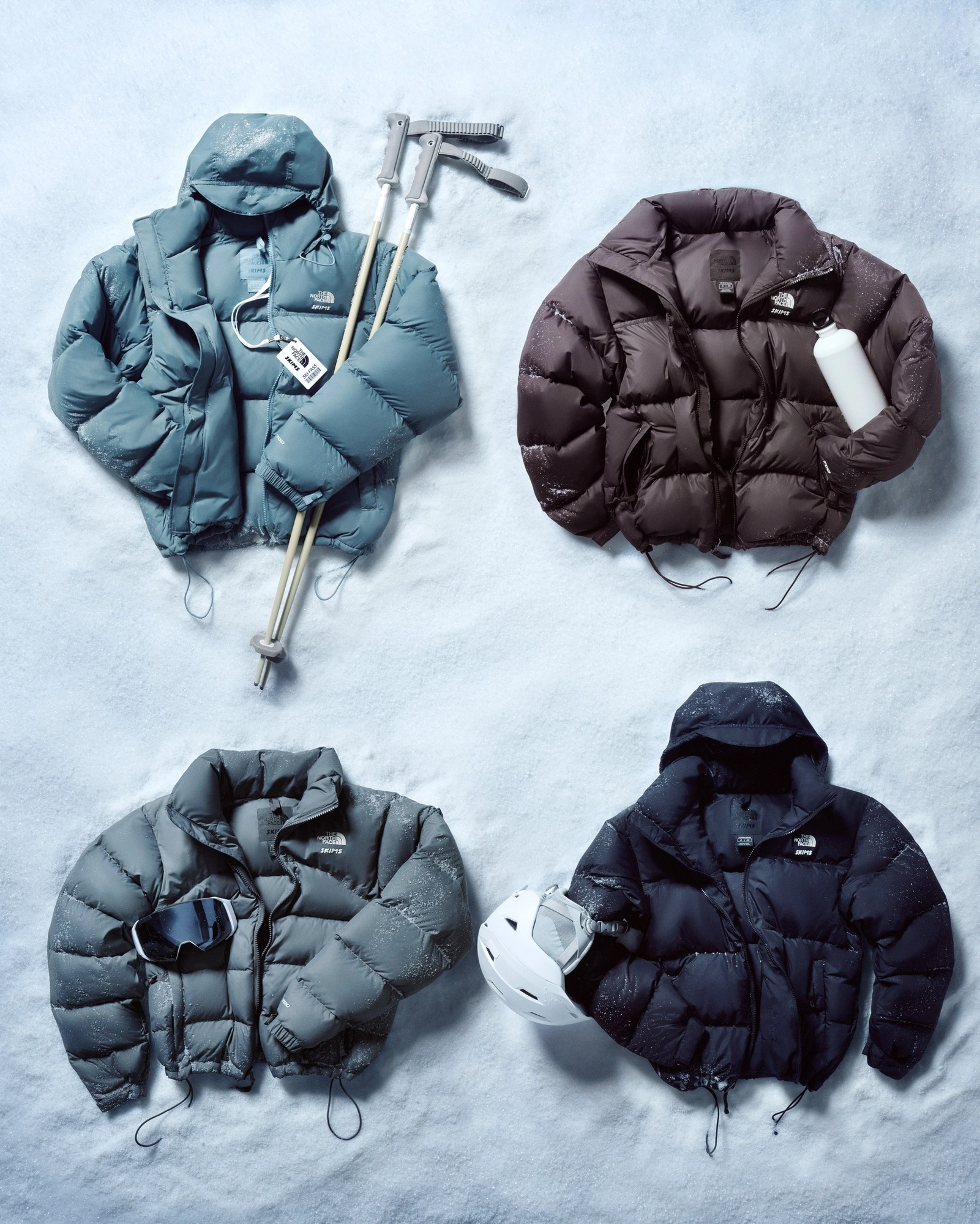 Doudoune Skims x North Face de différentes tailles et couleurs posés sur la neige