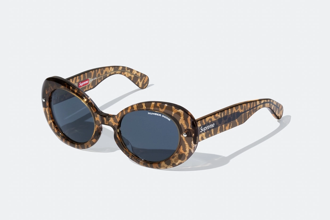 Lunette de soleil Supreme x Number Nine avec monture léopard posées sur fond blanc