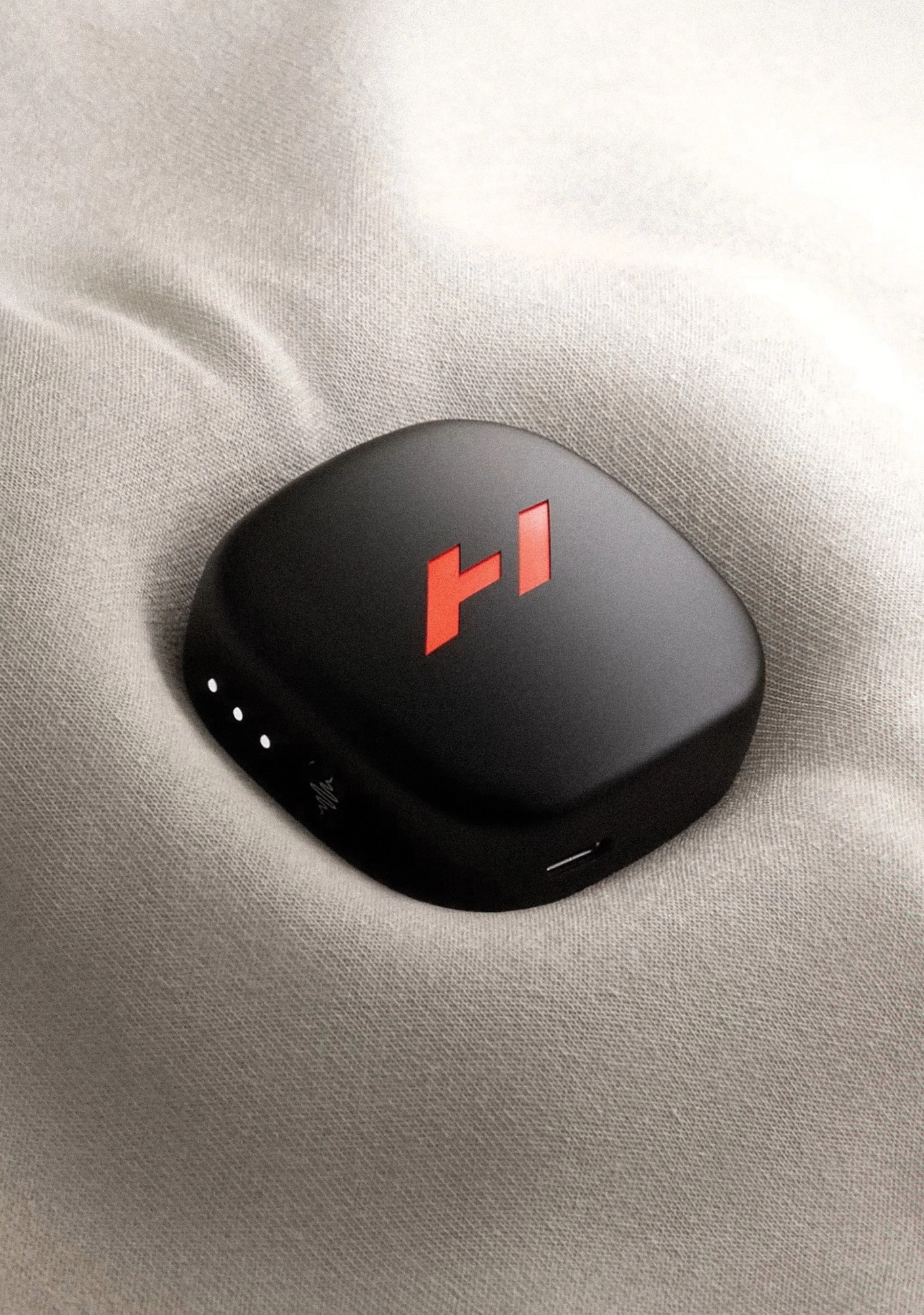 Hyperslide Pod amovible noir au logo Hyperice rouge posé sur du tissu