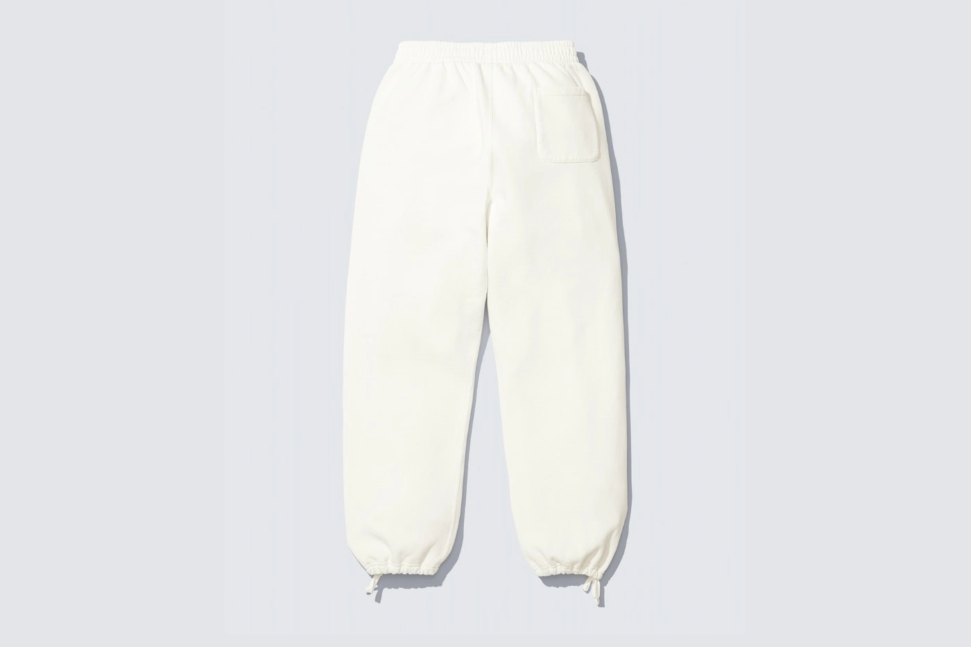 pantalon blanc Supreme Number Nine collaboration vue arrière sur fond gris clair
