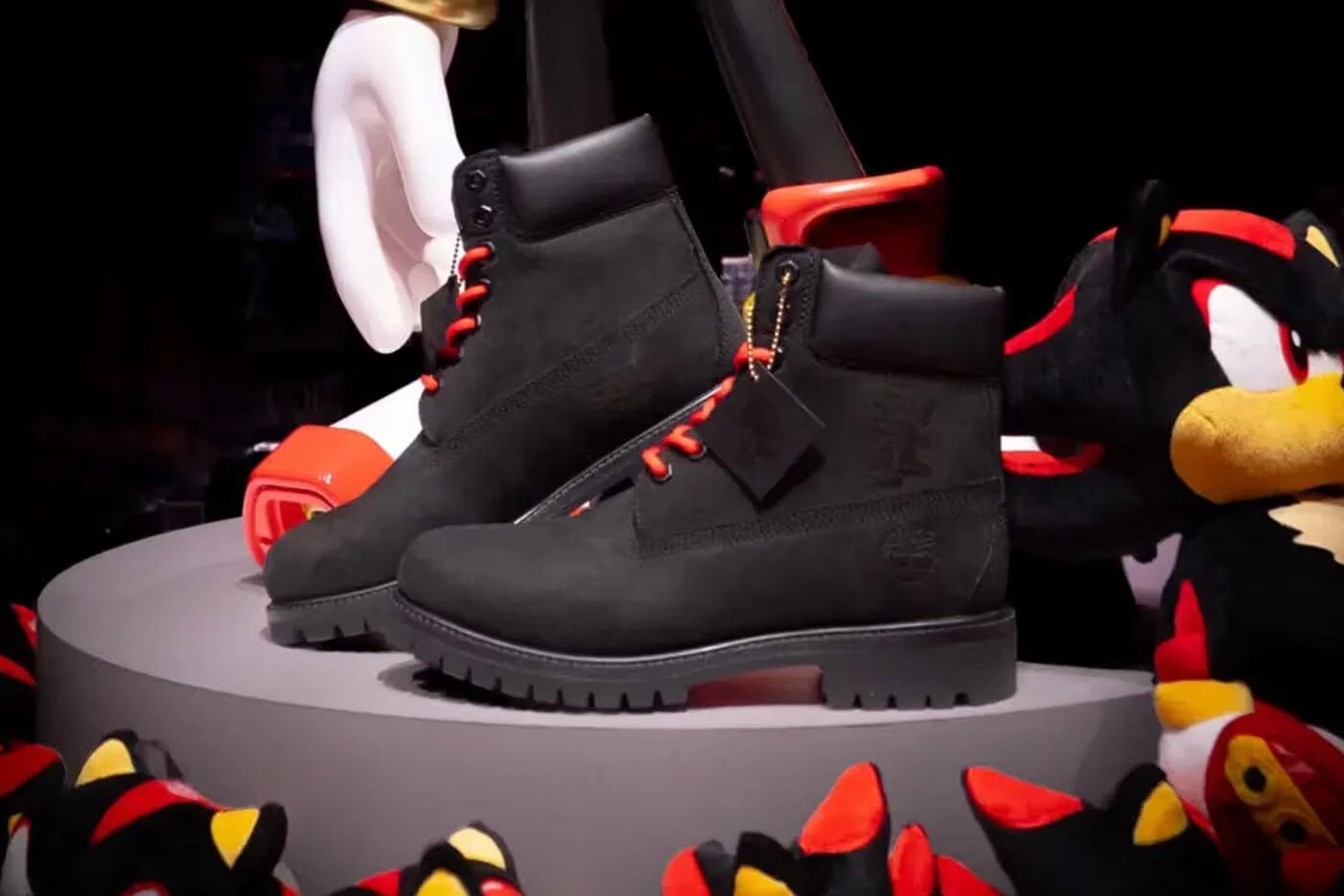Bottes Timberland noires avec lacets rouges en collaboration avec Shadow the Hedgehog, posées sur un présentoir