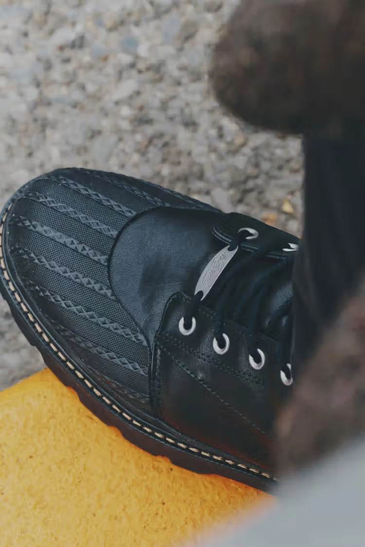 side close-up of a black Converse 1908 Bronco boot on a textured background