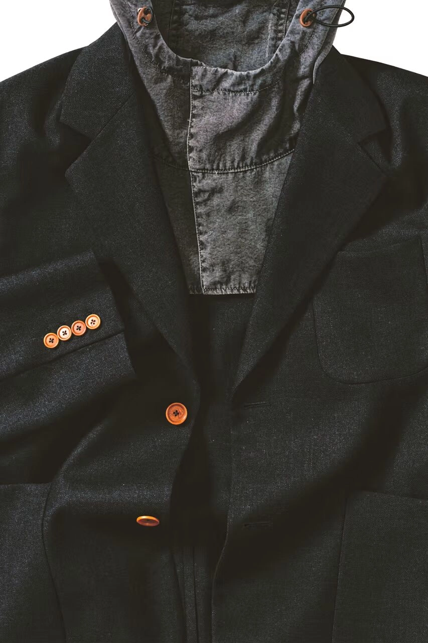 Veste noire de la collaboration C.P. Company x Our Legacy avec boutons orange et capuche grise