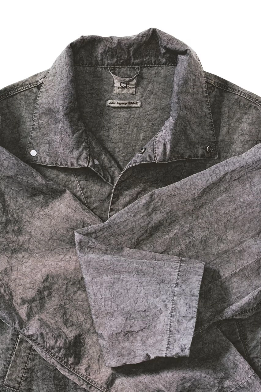 Veste grise C.P. Company x Our Legacy avec col rabattu sur fond blanc