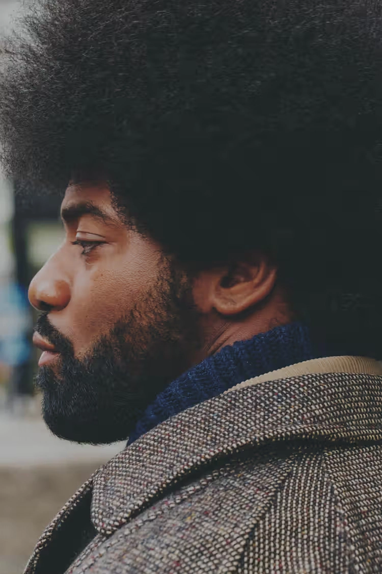 profile view of a man with a textured coat and blue collar