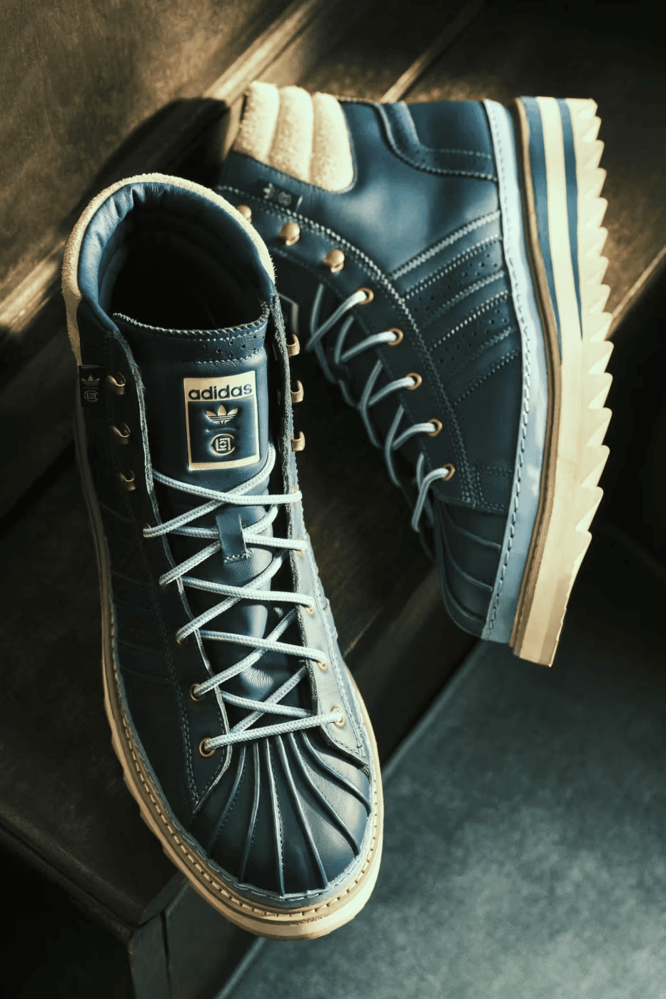 CLOT x adidas Pro Model blue sneakers facing up on a dark surface