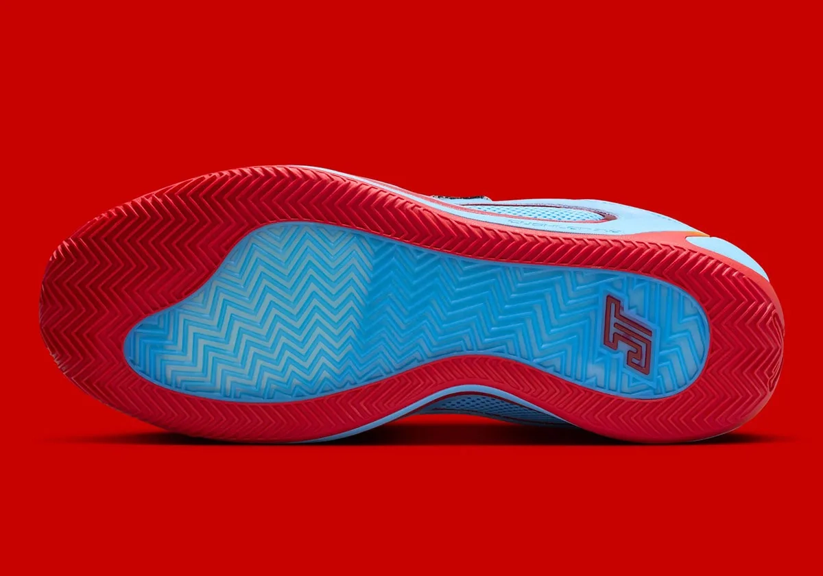 view of the red and blue sole of the Jordan Tatum 4 sneaker on a red background