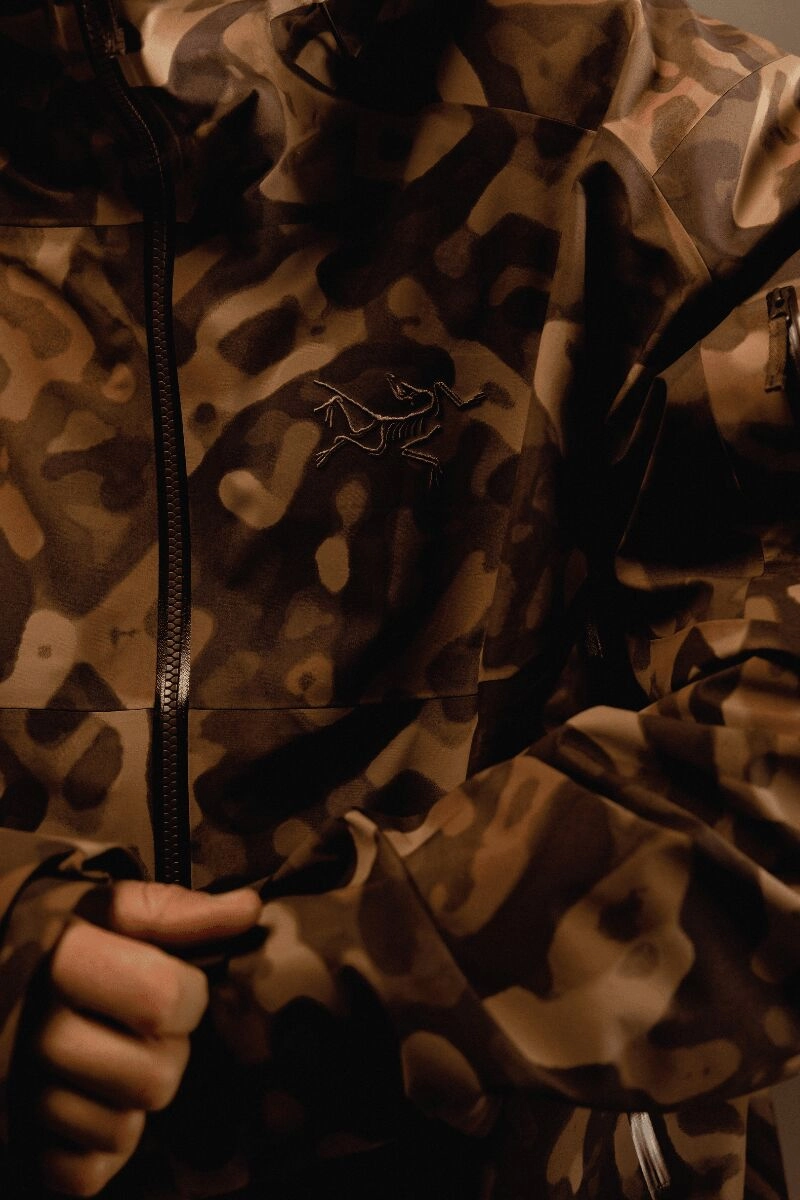 Détail d'une veste Arc'teryx Grottoflage marron avec logo visible sur la poitrine