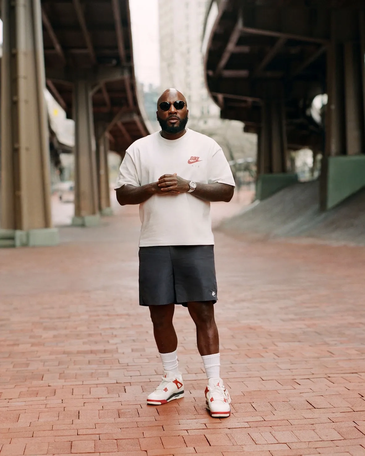 Jeezy standing wearing the Nigel Sylvester x Air Jordan 4 Sail Cinnabar