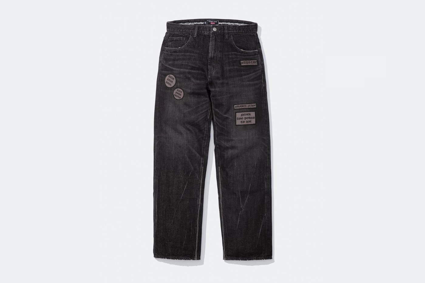 jean noir Supreme x Number Nine avec patchs stylisés sur fond blanc