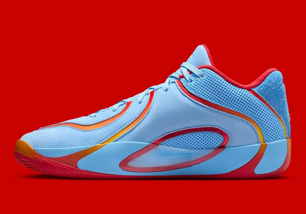 profil latéral de sneaker Jordan Tatum 4 bleu ciel et accents orange sur fond rouge