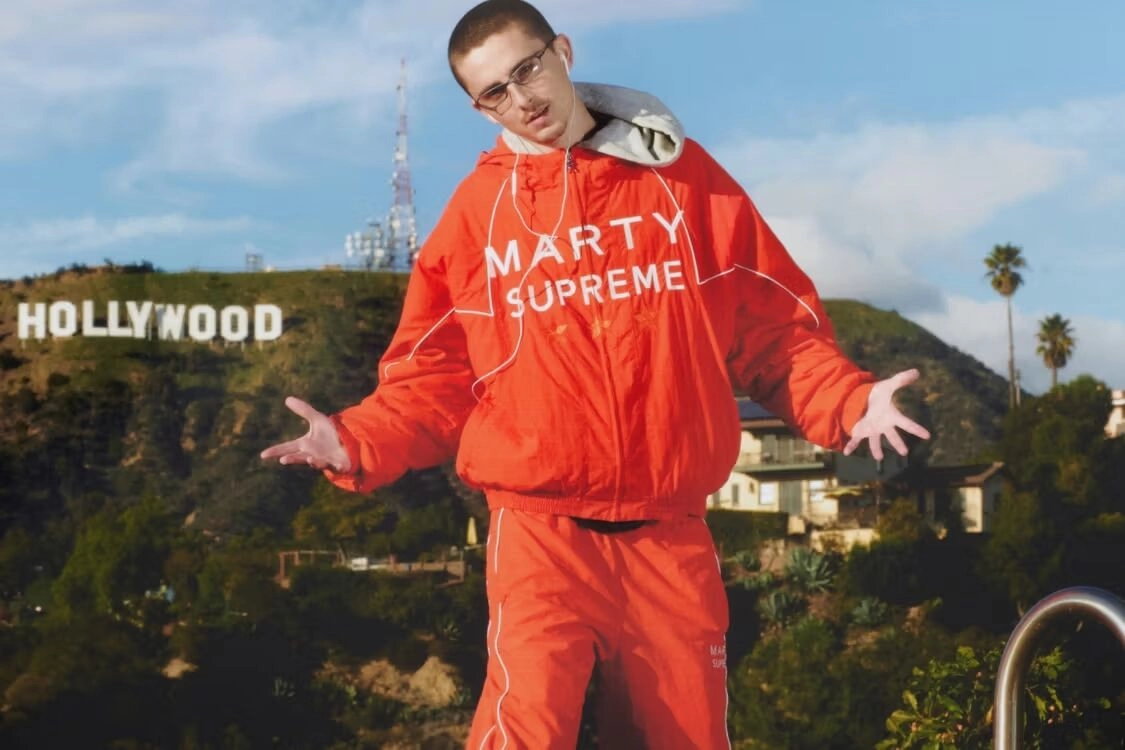 Personne portant ensemble Nahmias Marty Supreme rouge devant enseigne Hollywood