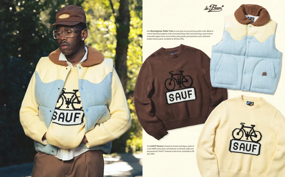 Tyler the creator wearing a blue and beige Le Fleur season 4 vest over a beige SAUF sweater, natural background