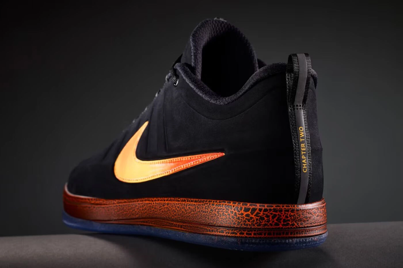 Sneaker noire Nike avec swoosh orange et détail "Chapter Two" vue latérale