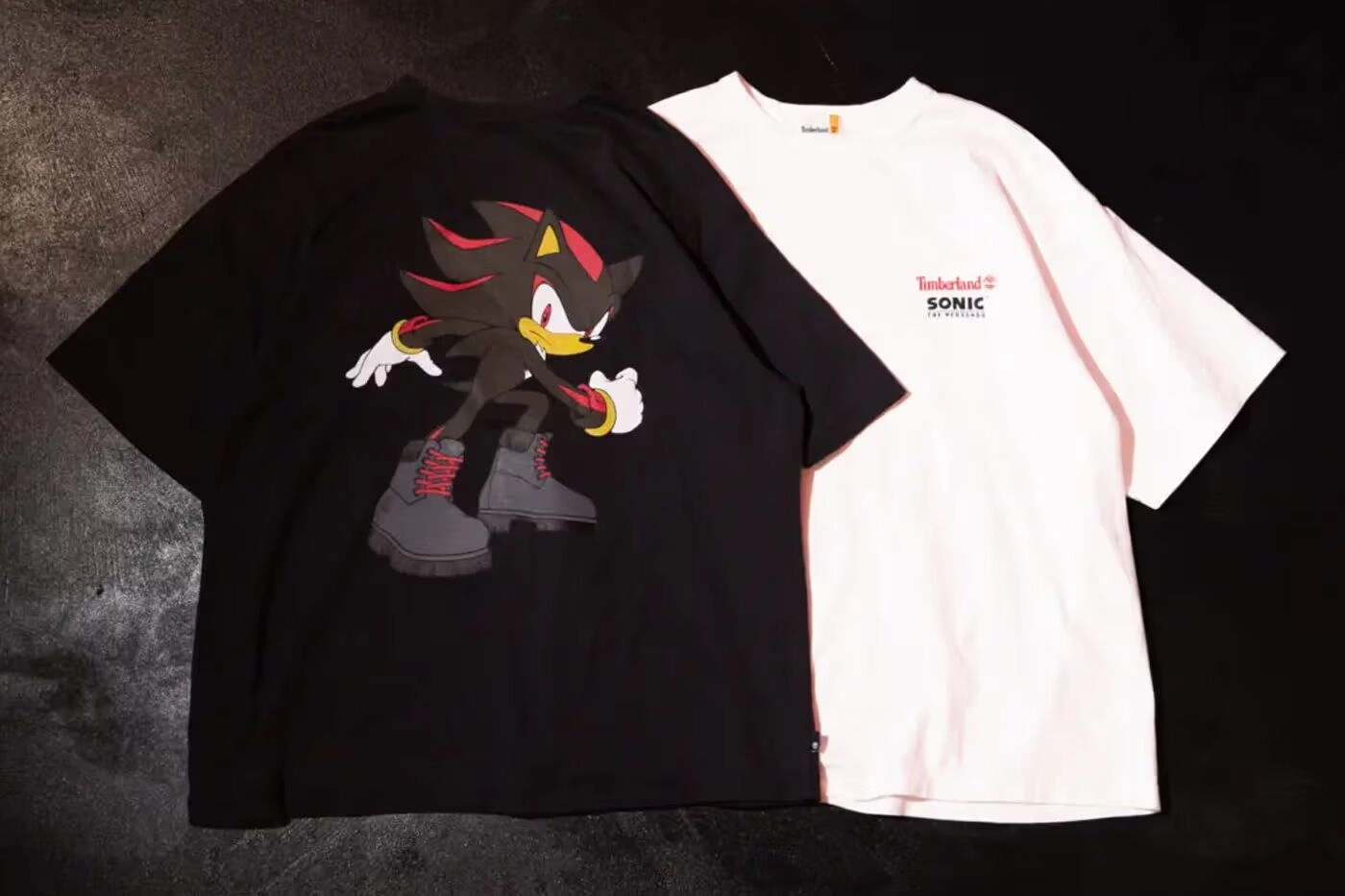 T-shirts noirs et blancs Timberland x Sega avec Shadow the Hedgehog affiché sur fond noir