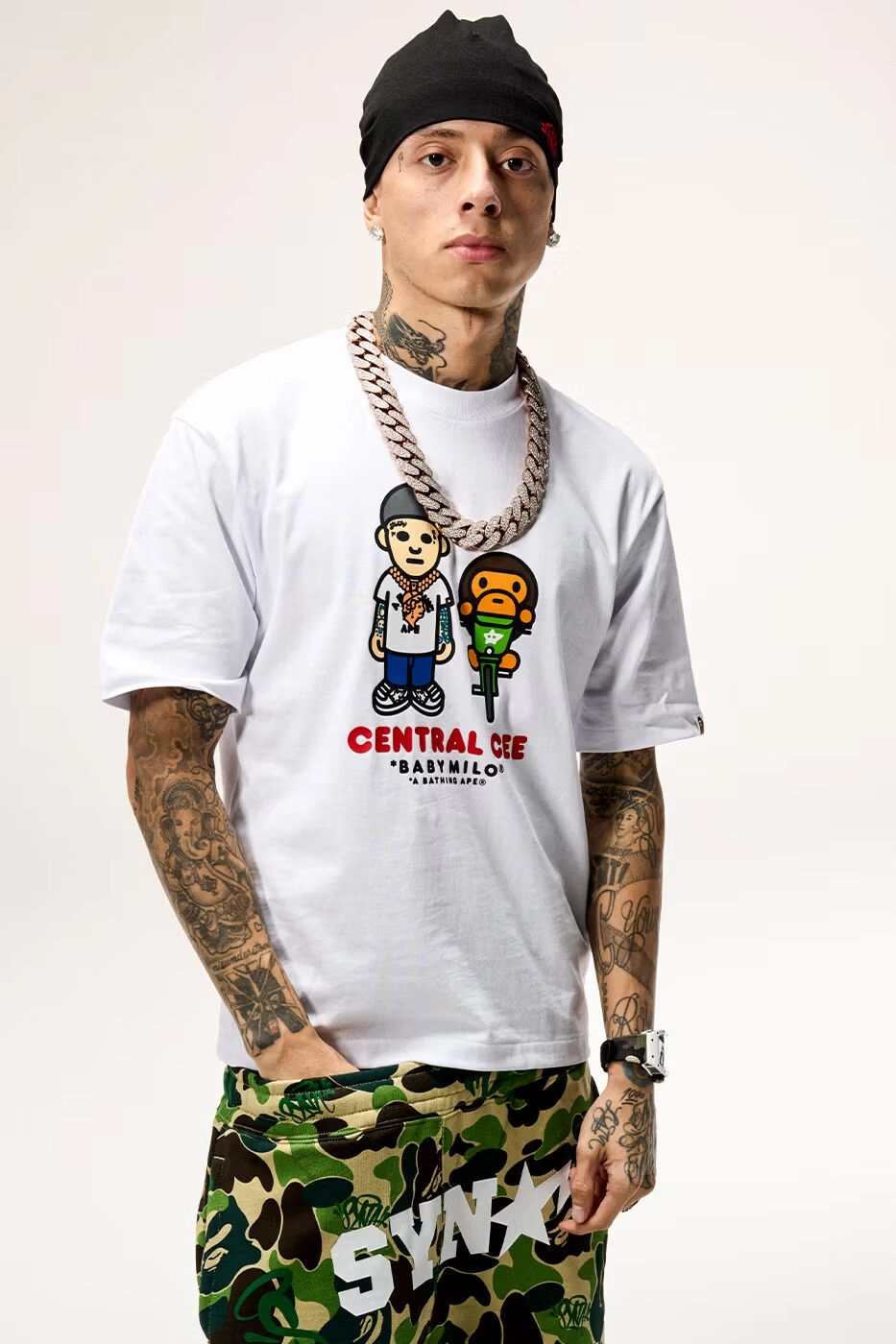 Central Cee portant un t-shirt blanc Central Cee x BAPE Baby Milo avec chaîne lourde