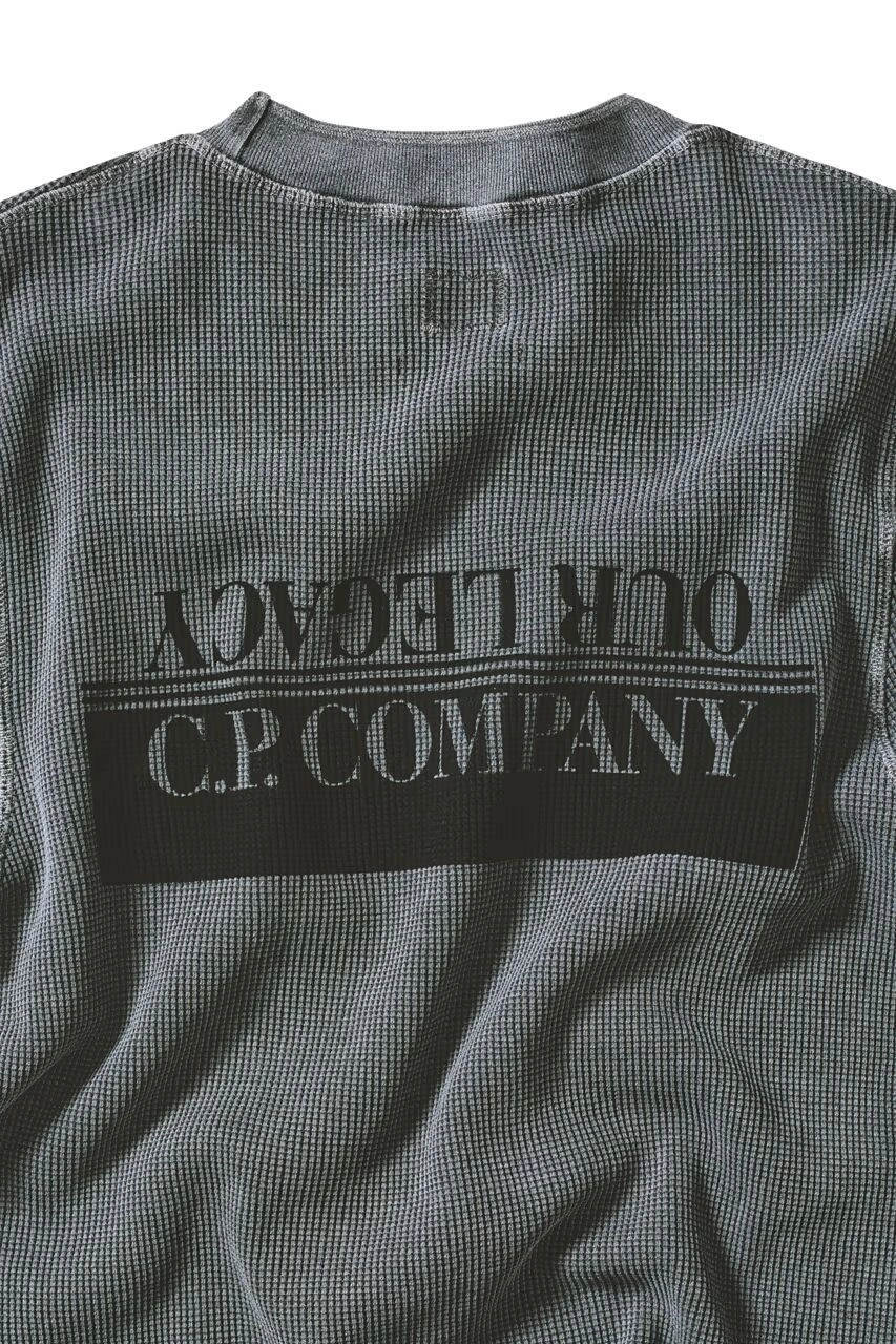Pull gris avec logo C.P. Company et Our Legacy, texture en gros plan
