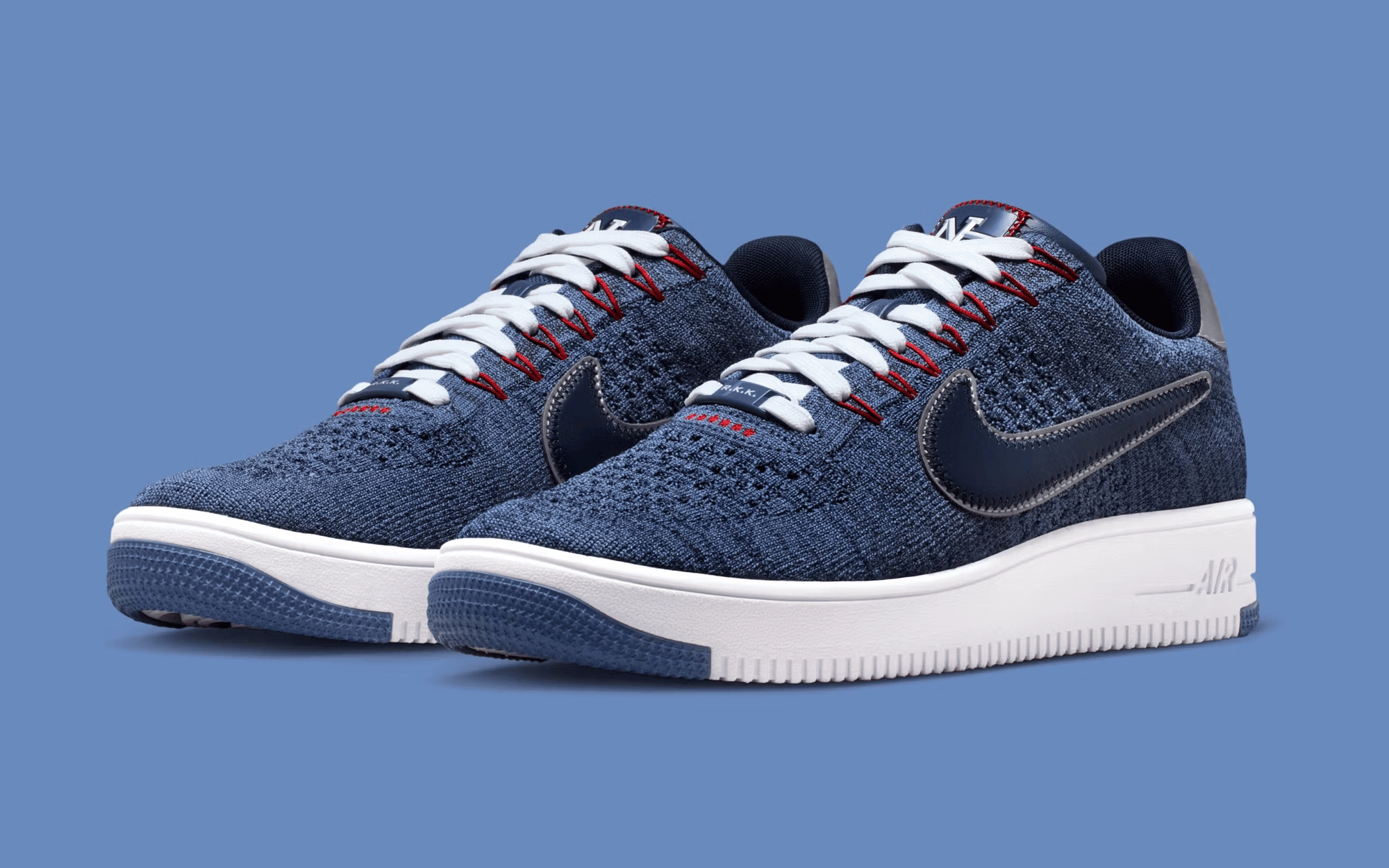 paire de sneakers Nike Air Force 1 Low Flyknit bleues avec swoosh bleu sur fond bleu