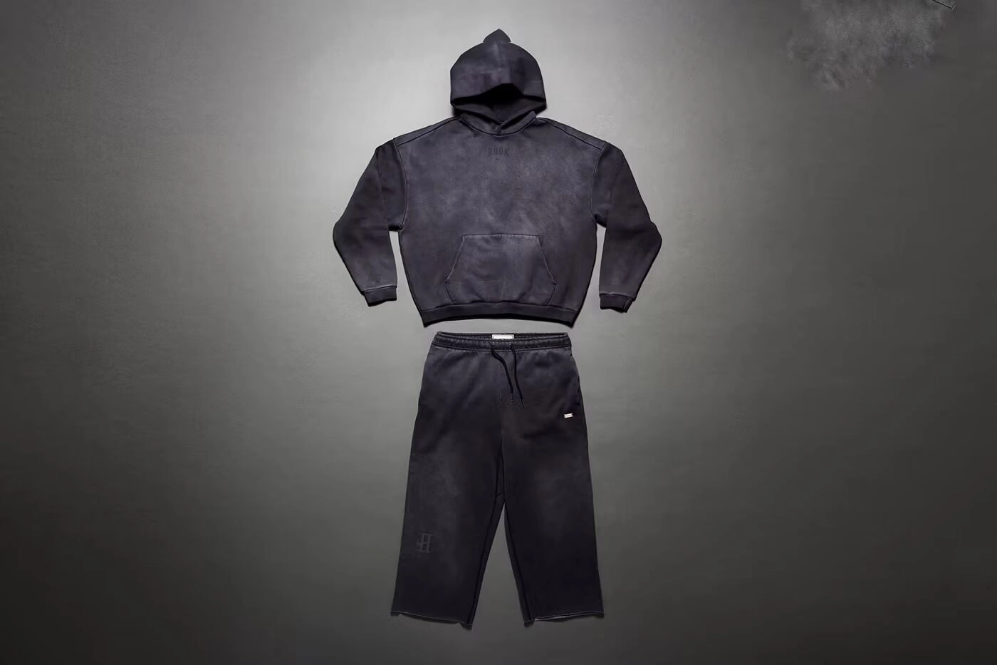 Vêtement noir Nike x Devin Booker avec sweat à capuche et pantalon sur fond gris